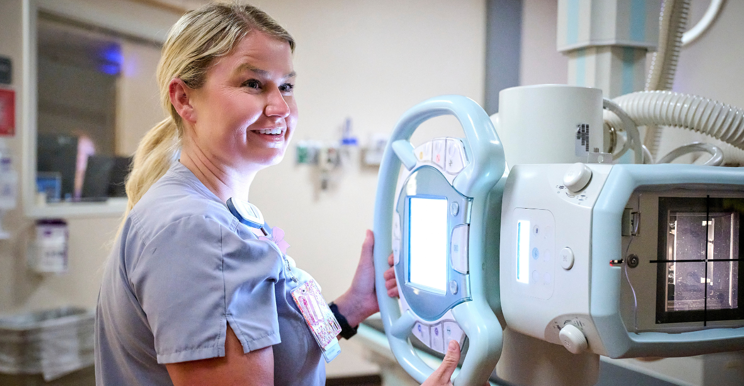 Woman smiling while operating an X-Ray machine
