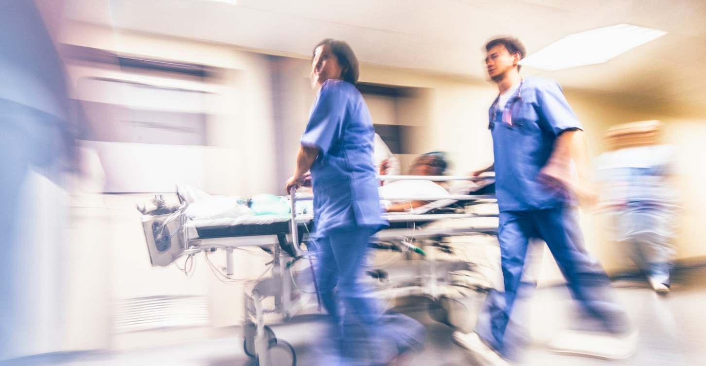 Two nurses rushing into an emergency room with a stretcher