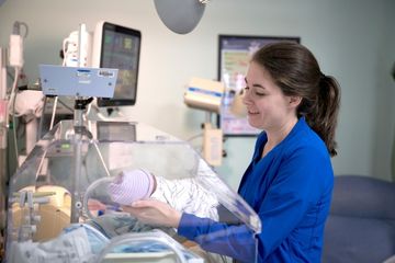 nurse holding NICU baby